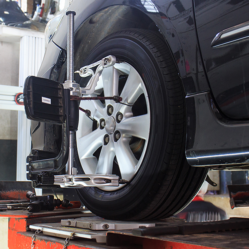 Car on stand with sensors on wheels for wheels alignment camber